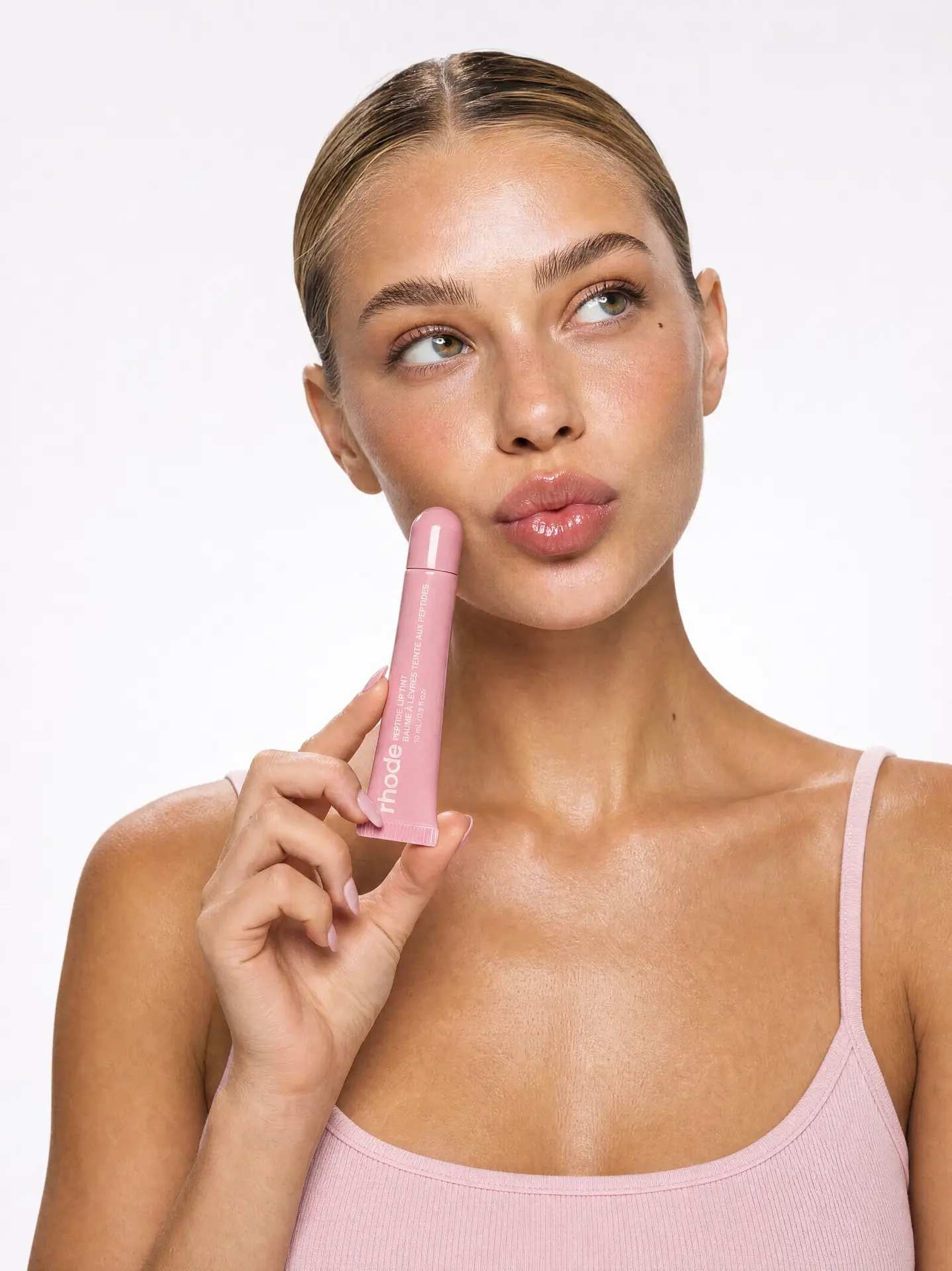 RHODE — MODEL PORTRAIT HOLDING THE PEPTIDE LIP TINT